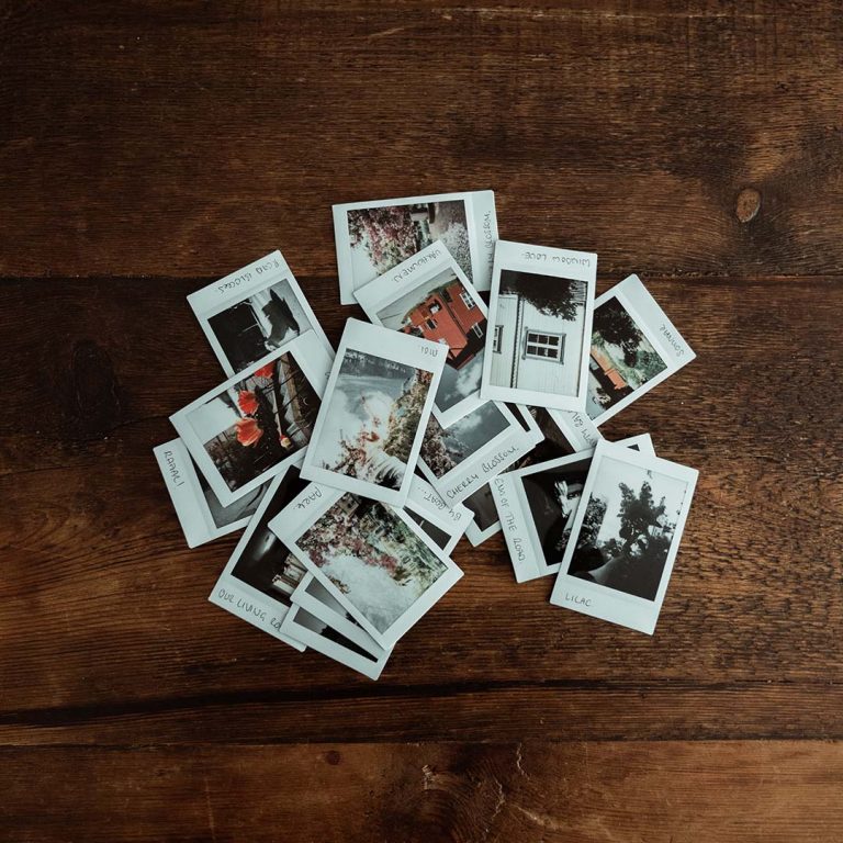 A stack of photos on a wooden table top